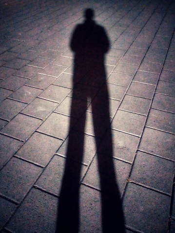 A man shadow stands in the darkness
