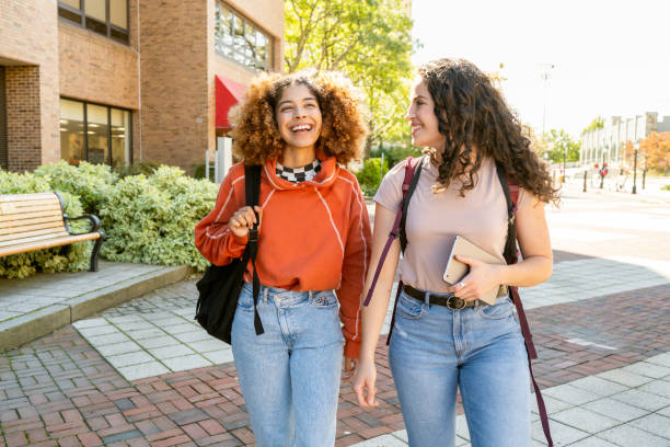 istock Female friends walking in university campus 1759903410