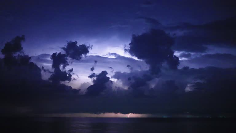 Beautiful thunderstorm with clouds and lightning over the night sea