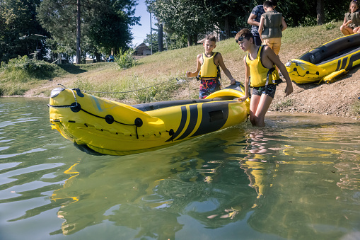 Kids kayaking to campsite in the lake