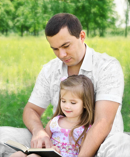 istock Father with daughter reading in the park 175993034