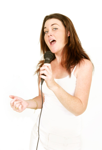 young woman holding a retro microphone and singing