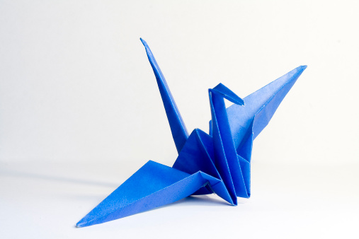 Original Japanese origami crane in white background.
