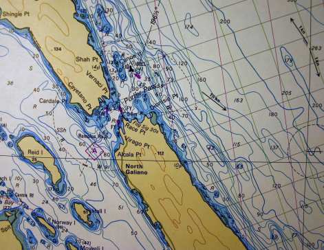 Macro shot of nautical chart showing Porlier Pass between Valdes and Galiano Island on the British Columbia coast.