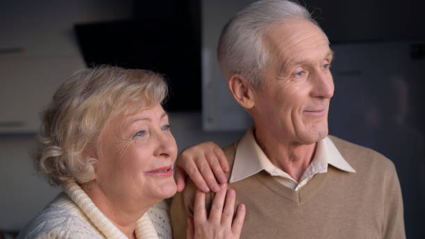 istock Nostalgic elderly couple smiling and hugging at home, reminiscing about nice memories from the past 1759957072