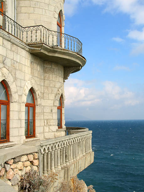 A fragment of a castle hanging over the deep aquamarine sea
