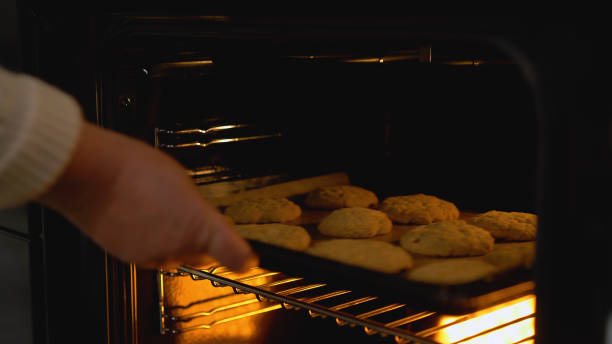 istock A grandma taking a baking pan with cookies from a hot oven, a cozy home atmosphere 1759958113
