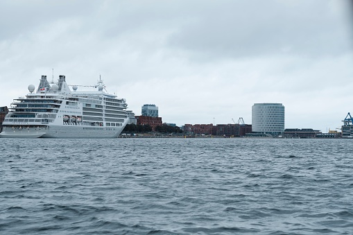 Copenhagen, Denmark – October 06, 2023: A majestic white cruise ship is navigating a vast expanse of ocean, its size and grandeur giving it an awe-inspiring presence