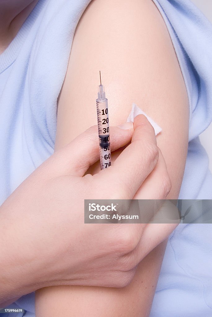 Insulin Injection Woman preparing for an insulin injection. Shallow DOF. Adult Stock Photo