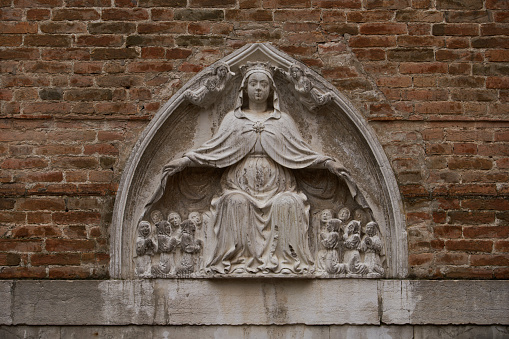 Sculpture of Virgin Of Mercy (Italian: Madonna della Misericordia) on the facade of San Toma church in Venezia. Venice - 5 May, 2019