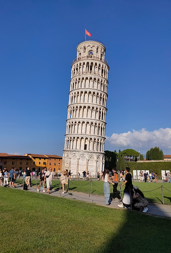 Pisa, Italy - October 4, 2023: People going near Leaning tower of Pisa, Italy and blue sky