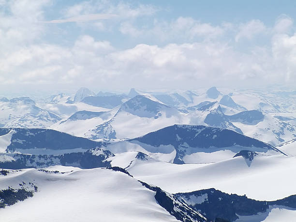 Alpine mountains with snow and clouds stock photo