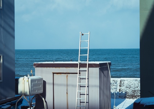 A large bathroom stall with a beautiful view of the winter sea