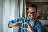Happy Caucasian man making a heart sign with his hands