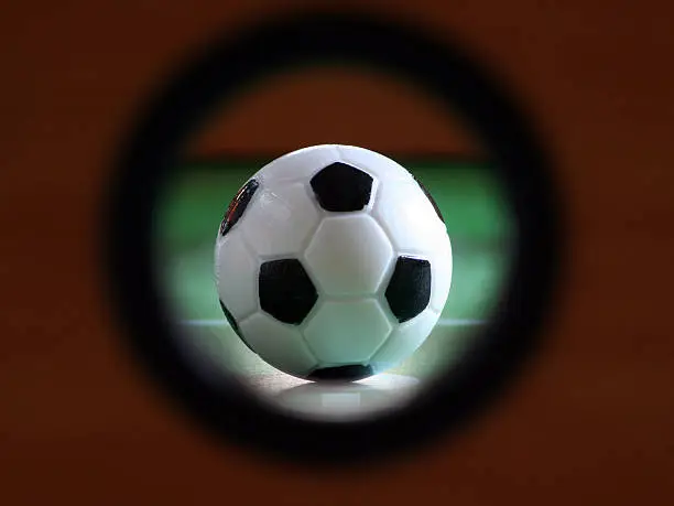 Photo of Ssoccer ball on fussball table, seen throuhg hole in sidepanel