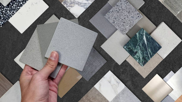 istock interior architect compare grainy quartz samples with ceramic tiles, artificial stones, marbles, stainless, quartz, terrazzo that placed on black stone table. selected material for idea design. 1759998060