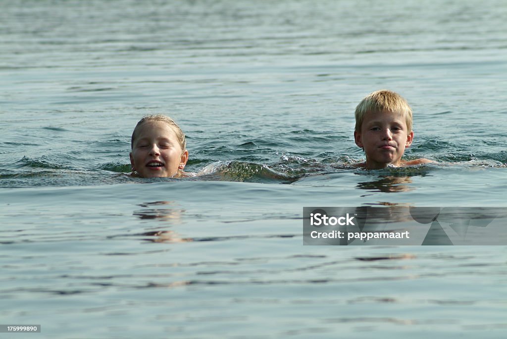 Dos niños nadar en el lago niño y niña - Foto de stock de Lago libre de derechos