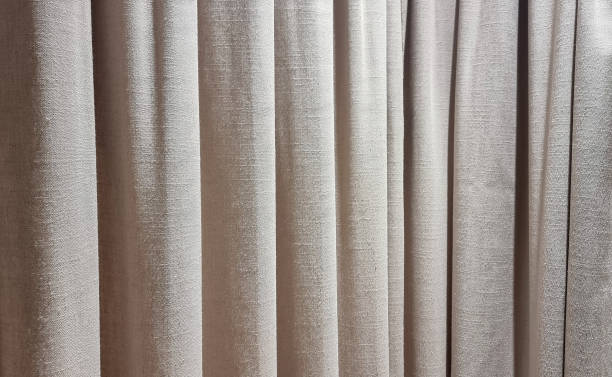 istock close up beige curtains use as background. sack cloth texture drape for minimal interior design.  brown natural linen drape curtains background. beautiful interior home design backdrop. 1759999036