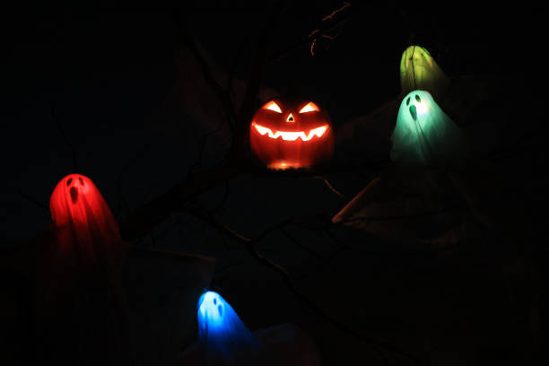 istock Halloween Pumpkin and the multicolor  ghost flying on the tree at night in the dead forest 1760010996