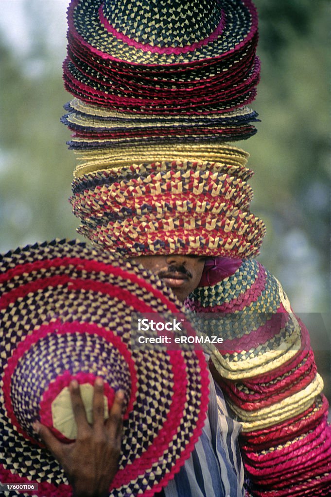 Hats Off ! Hawker selling straw hats - fully loaded - one hat too many ! Adult Stock Photo