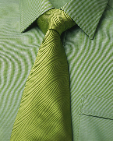 A green shirt and a green tie with a windsor knot.