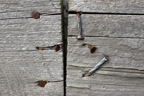 Rusty nails in an old split-rail fence board