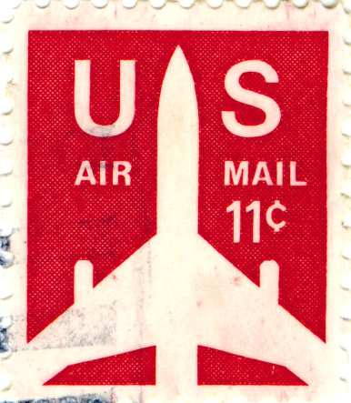 A scan of a 1970s US Air Mail 11 cent stamp with a jet plane with a red background