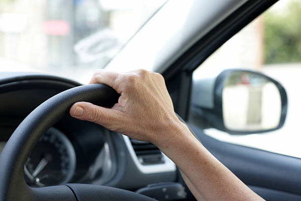 istock Woman driving hand on steering wheel 176005220