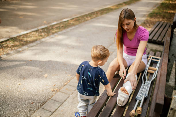 istock Woman with cast on her leg spending time with her son in park 1760062037