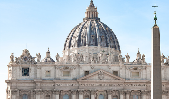 Vatican, January 01 -- A blanket of fog envelops the dome of St. Peter and the monumental statues on the facade of the Basilica and on Bernini's Colonnade (left). Characterized by giant columns and pilasters, the immense facade of San Pietro (118 meters wide and 48 high), was conceived by the architect Carlo Maderno to complete Michelangelo's previous project and built between 1608 and 1614. The Basilica of St. Peter's, in the Vatican, is the center of the Catholic religion, one of the most visited places in the world and in Rome for its immense artistic and architectural treasures. In 1980 the historic center of Rome was declared a World Heritage Site by Unesco. Super wide angle image in high definition format.