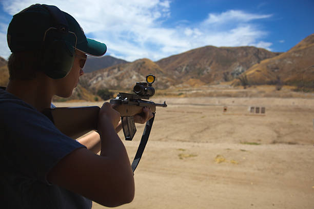 young man shooting на пистолет диапазон или оружие club в пустыне - rifle range стоковые фото и изображения