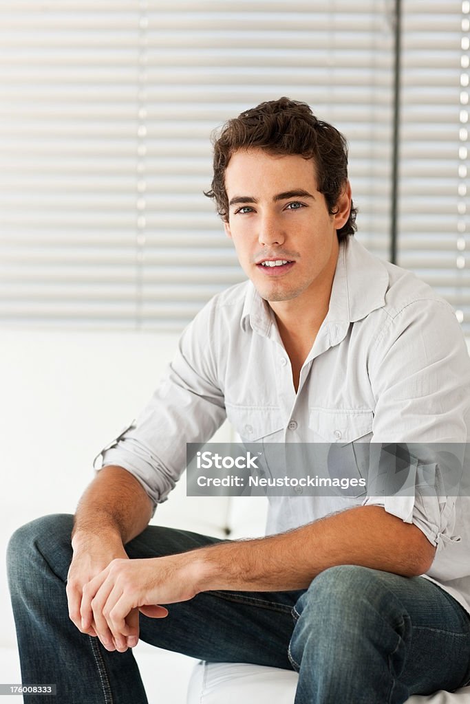 Bel giovane uomo seduto a casa - Foto stock royalty-free di 20-24 anni