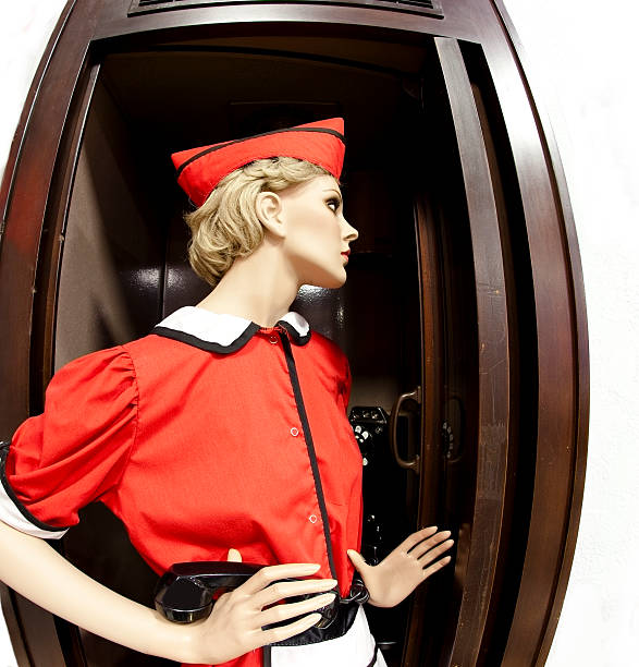 Car hop mannequin in old fashioned telephone booth.