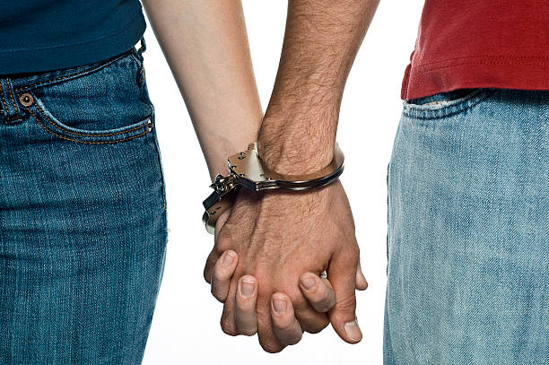 Handcuffed Picture of a young couple handcuffed. couple hope sky blue stock pictures, royalty-free photos & images