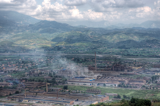 The Albanian city of Elbasan with communist-era factories and rolling hills in the distance. High dynamic range photo. 