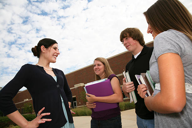 istock Students Talking to their teacher outside of school building 176010401