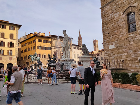 Florence, Italy - September 30, 2023: People going near Fountain of Neptune - a fountain in Florence, situated on the Piazza della Signoria or Signoria square at Italy