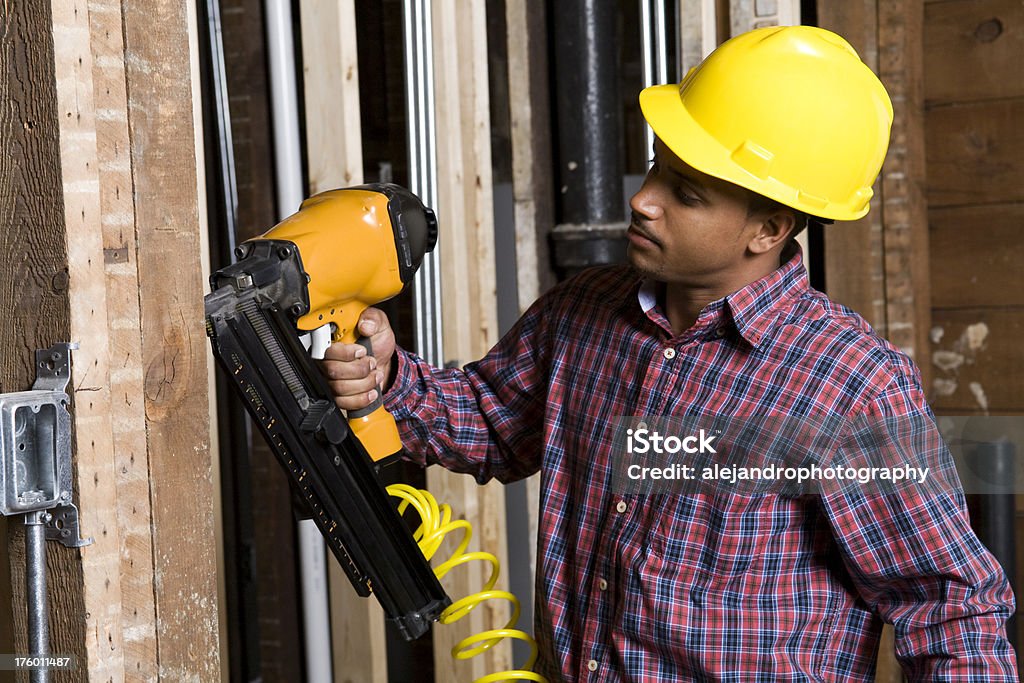 Trabalhador de Construção étnica usando uma arma de Unha - Foto de stock de Arma de Fogo royalty-free