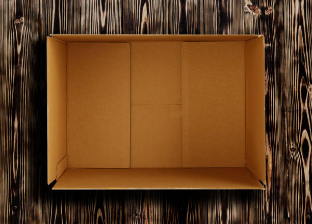 High quality opened rectangular blank empty cardboard brown box isolated on wooden background. Front view angle. Closeup studio shot for postal delivery and suitable for food, cosmetic or medical packaging.