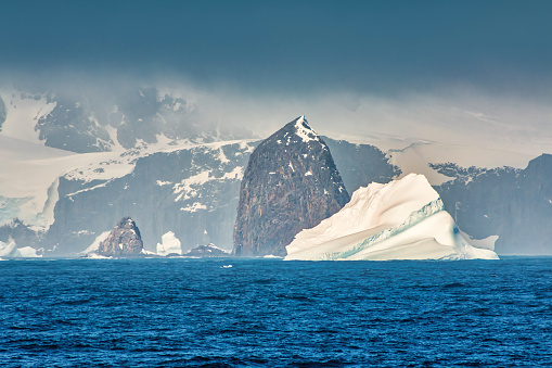 Rocky coastline landscape with iceberg in the Antarctic Peninsula, Antarctica.