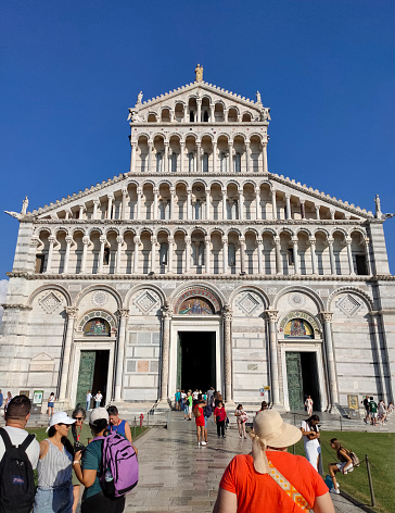 Pisa, Italy - October 4, 2023: People going near Leaning tower of Pisa, Italy and blue sky