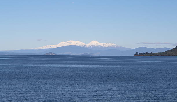 Lake Taupo during Winter. Mt Ruapehu is in the distance "Snow covered Mounts Ruapehu, Ngauruahoe and Tangariro lie in the distance across a placid Lake Taupo on a clear winters day.Please see my other NZ images here:" tongariro national park photos stock pictures, royalty-free photos & images