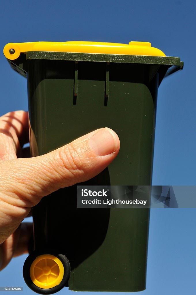 Hand holding a miniature Australian recycle bin A hand holding a miniature Australian recycle bin Australia Stock Photo