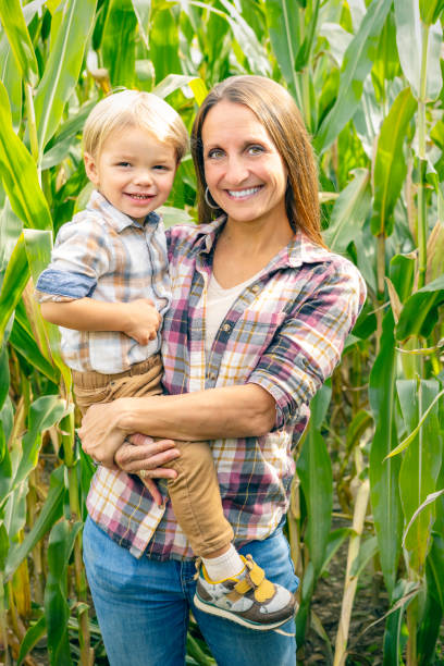 istock Mom Holding Toddler Son by Corn Stalks 1760132842