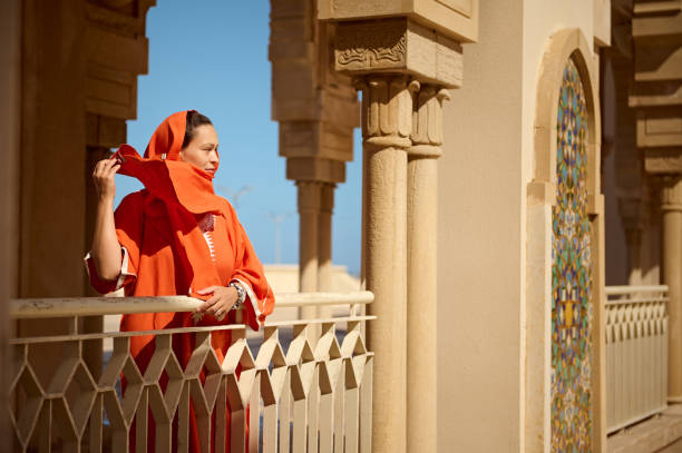 istock Beautiful Muslim woman standing between marble columns, looking into the distance, while wind blowing shawl on her head 1760133366