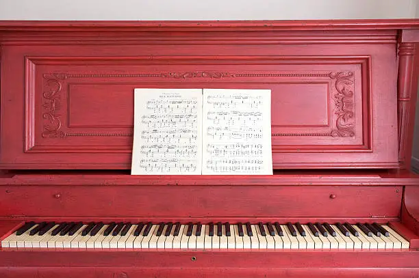 Antique red piano holds Chopin's music open to Deux Nocturnes.