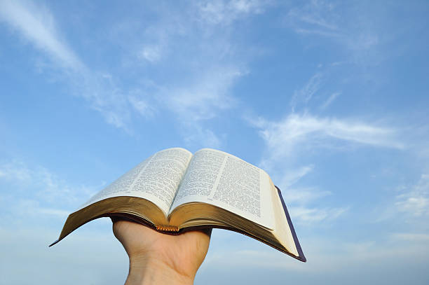 istock A hand holding a bible up against a blue sky 176014783