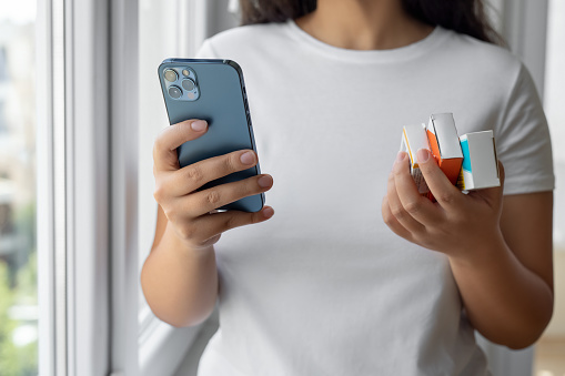 Woman consulting medication information with cell phone