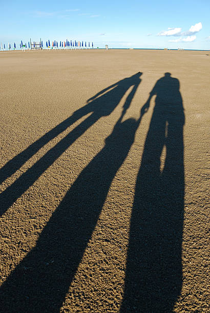 família sombras na praia - silhouette three people beach horizon - fotografias e filmes do acervo