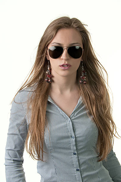 Fashion model "Attractive young and sexy long haired model posing with sunglasses and long earings, isolated on white." fine art portrait pin up girl glamour beauty stock pictures, royalty-free photos & images